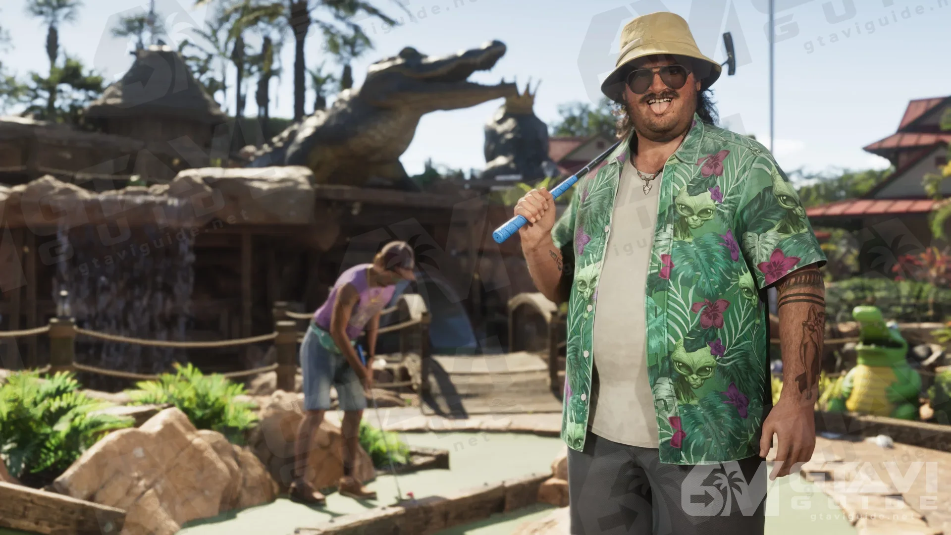 Cal wearing a green patterned shirt at a location with an alligator figure.