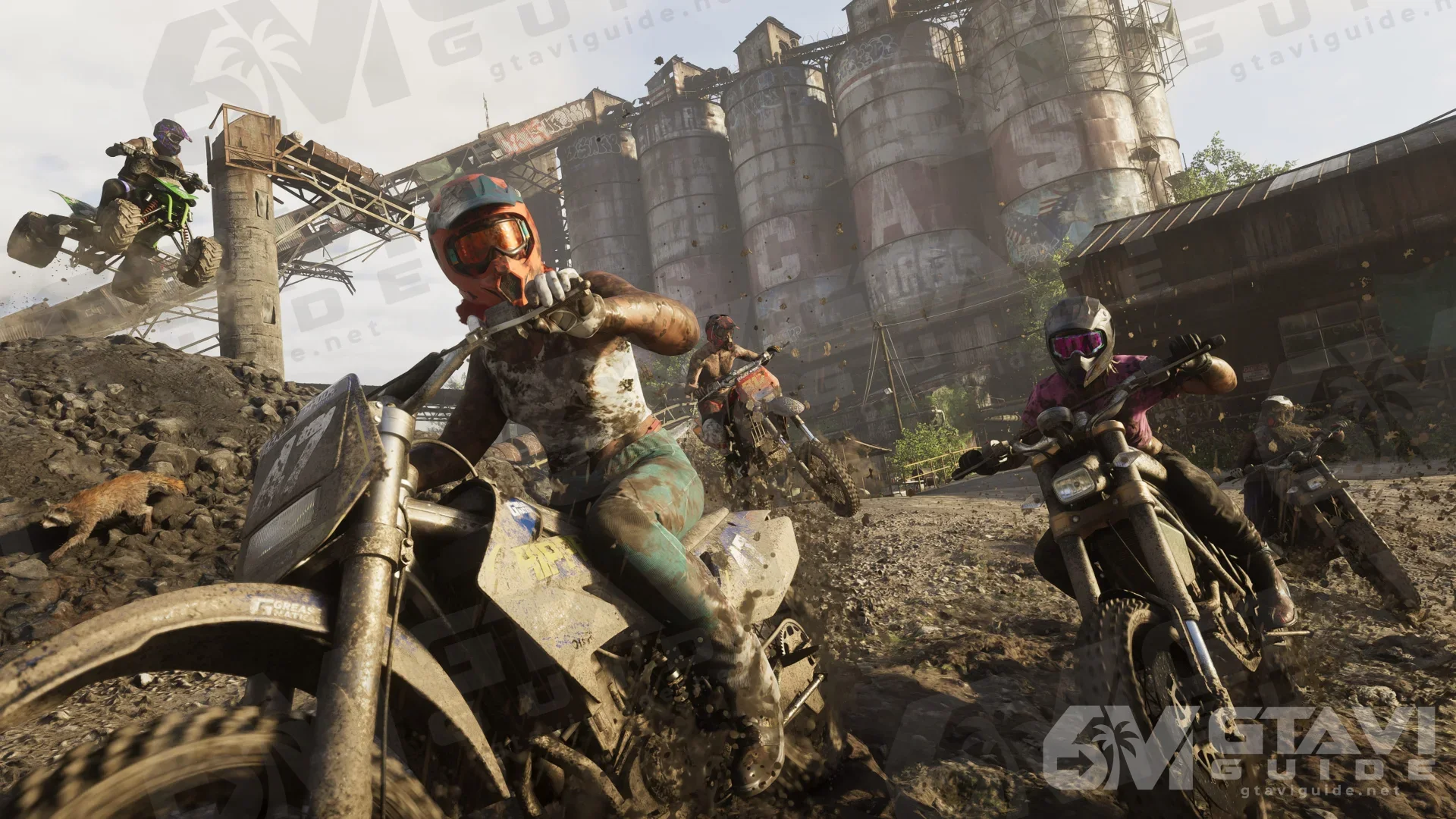 Riders on dirt bikes near industrial structures.